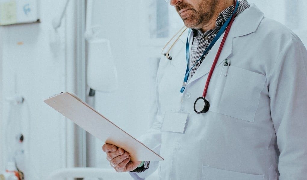 physician reading clipboard