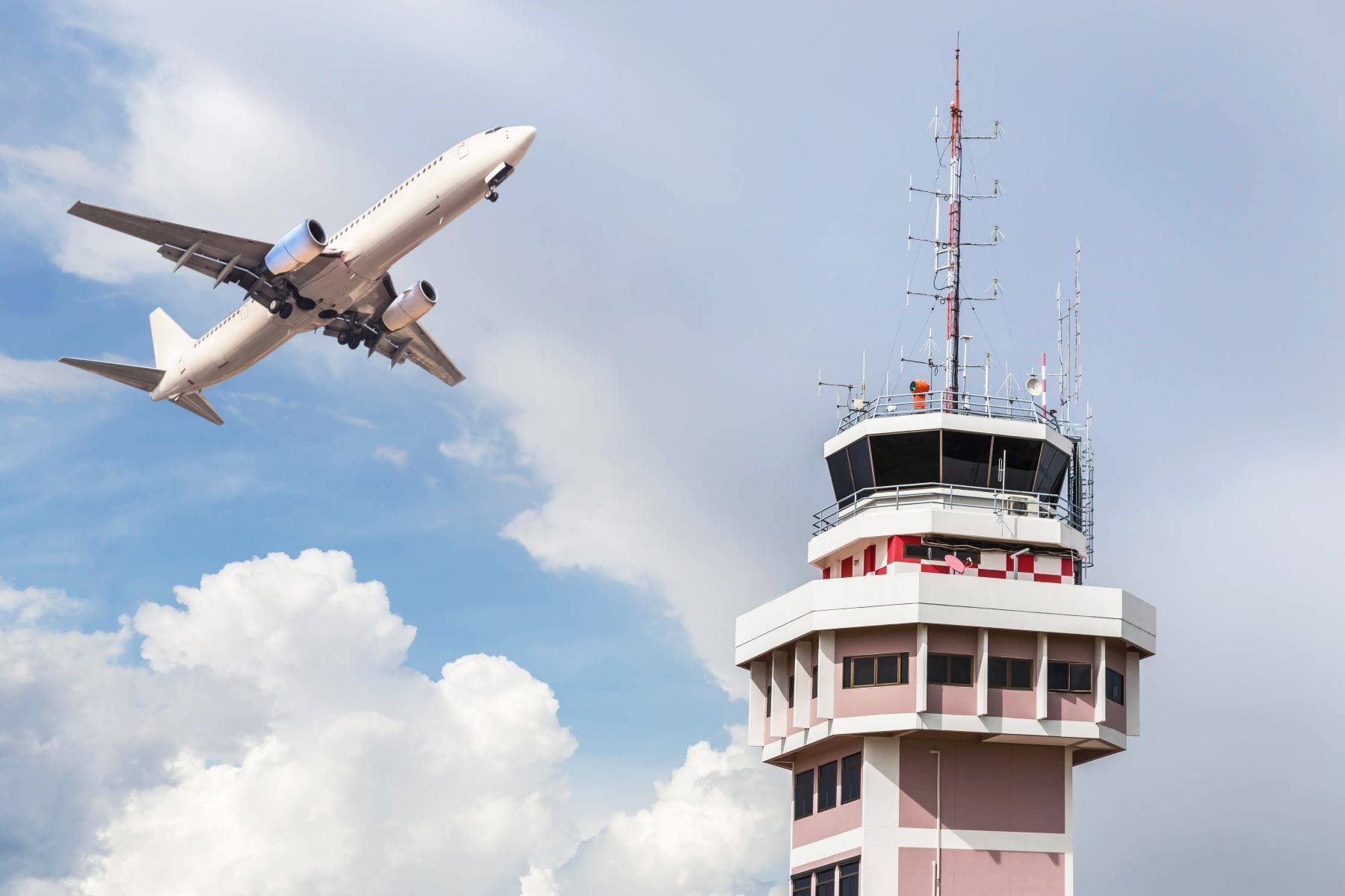 Air traffic control tower with passenger airplane