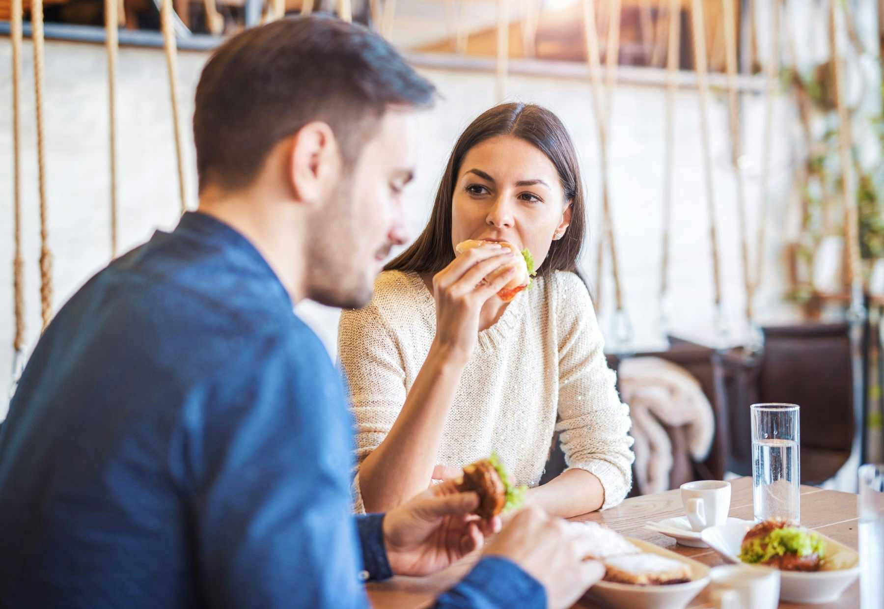 Young couple eating sandwiches