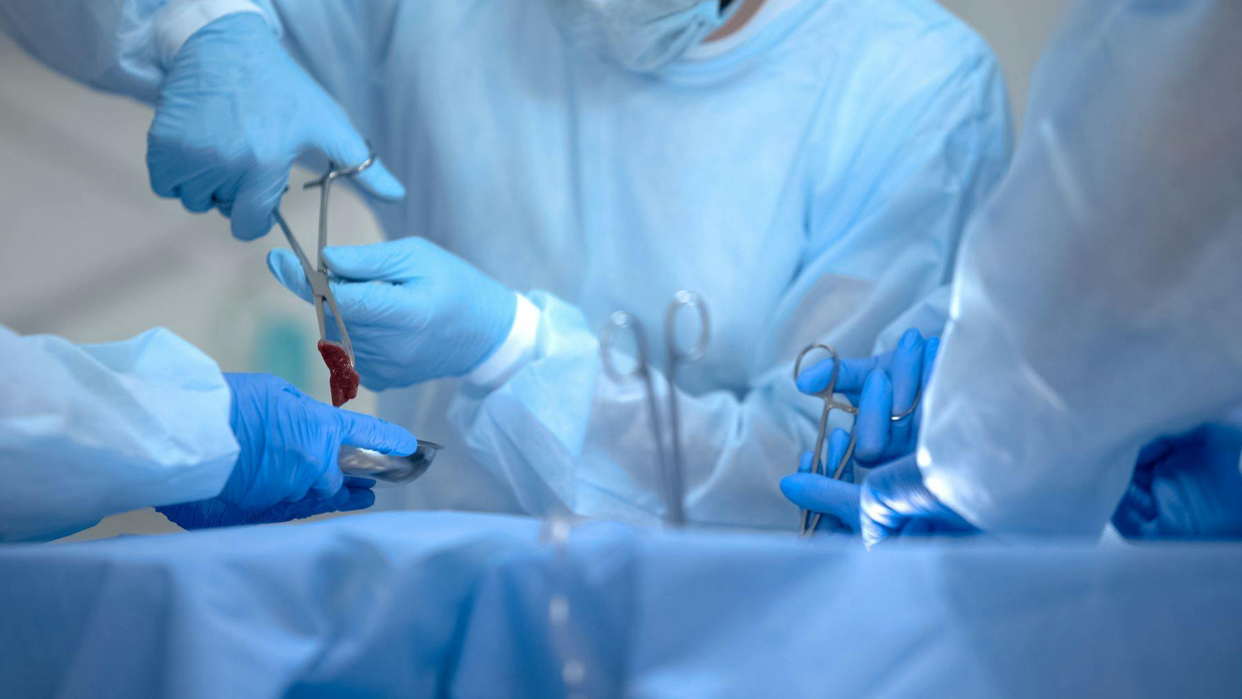 Surgeon removing tumor