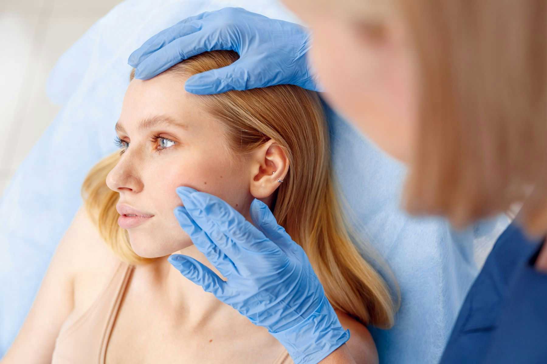 Dermatologist Inspecting Woman's Cheek