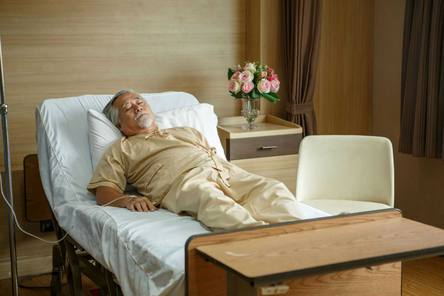 Elderly man in nursing home bed
