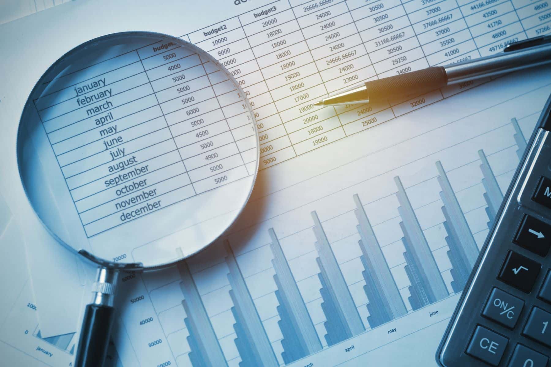 Business documents accounting with calculator, pen and magnifying glass