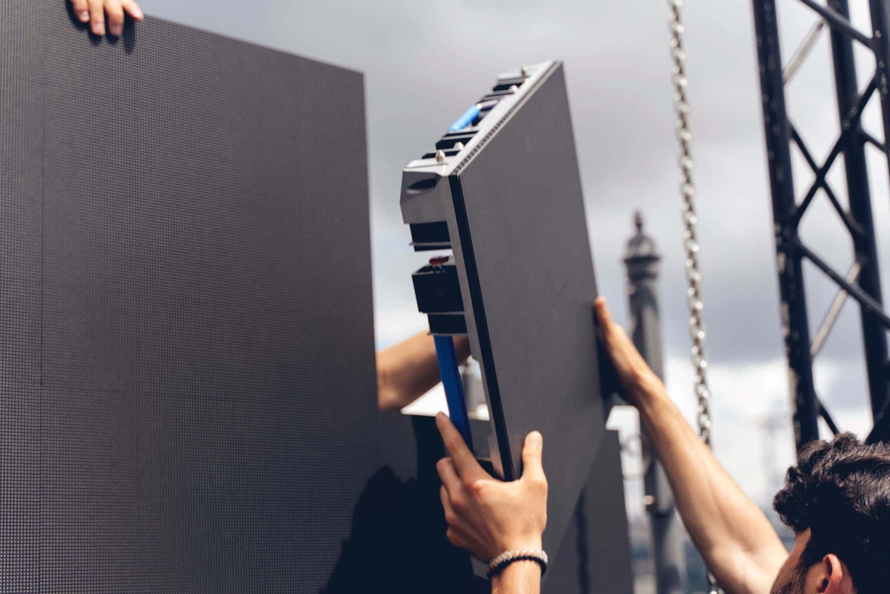 Workers assembling stage screen with panels