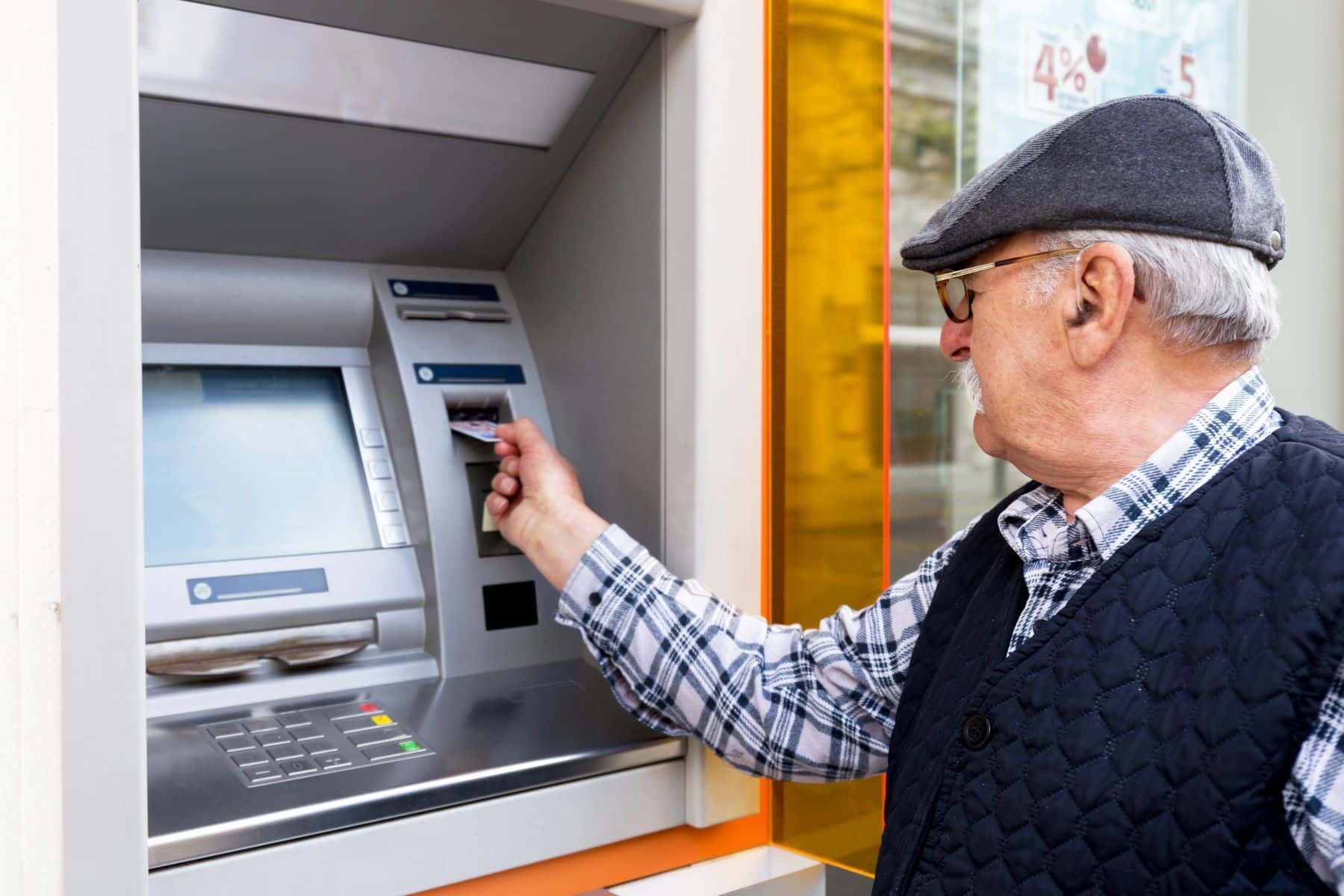 Elderly man using ATM