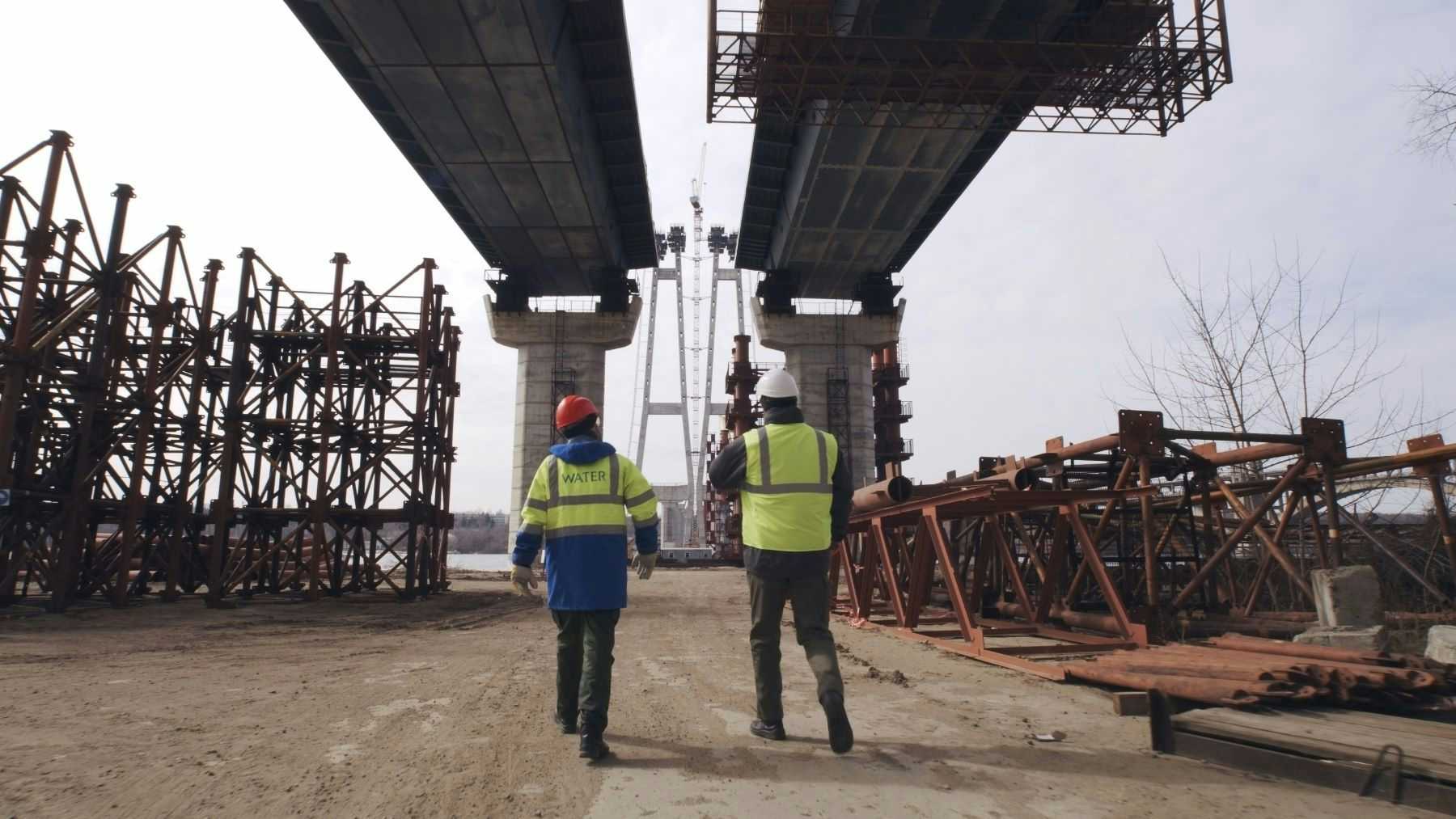 Construction workers under bridge