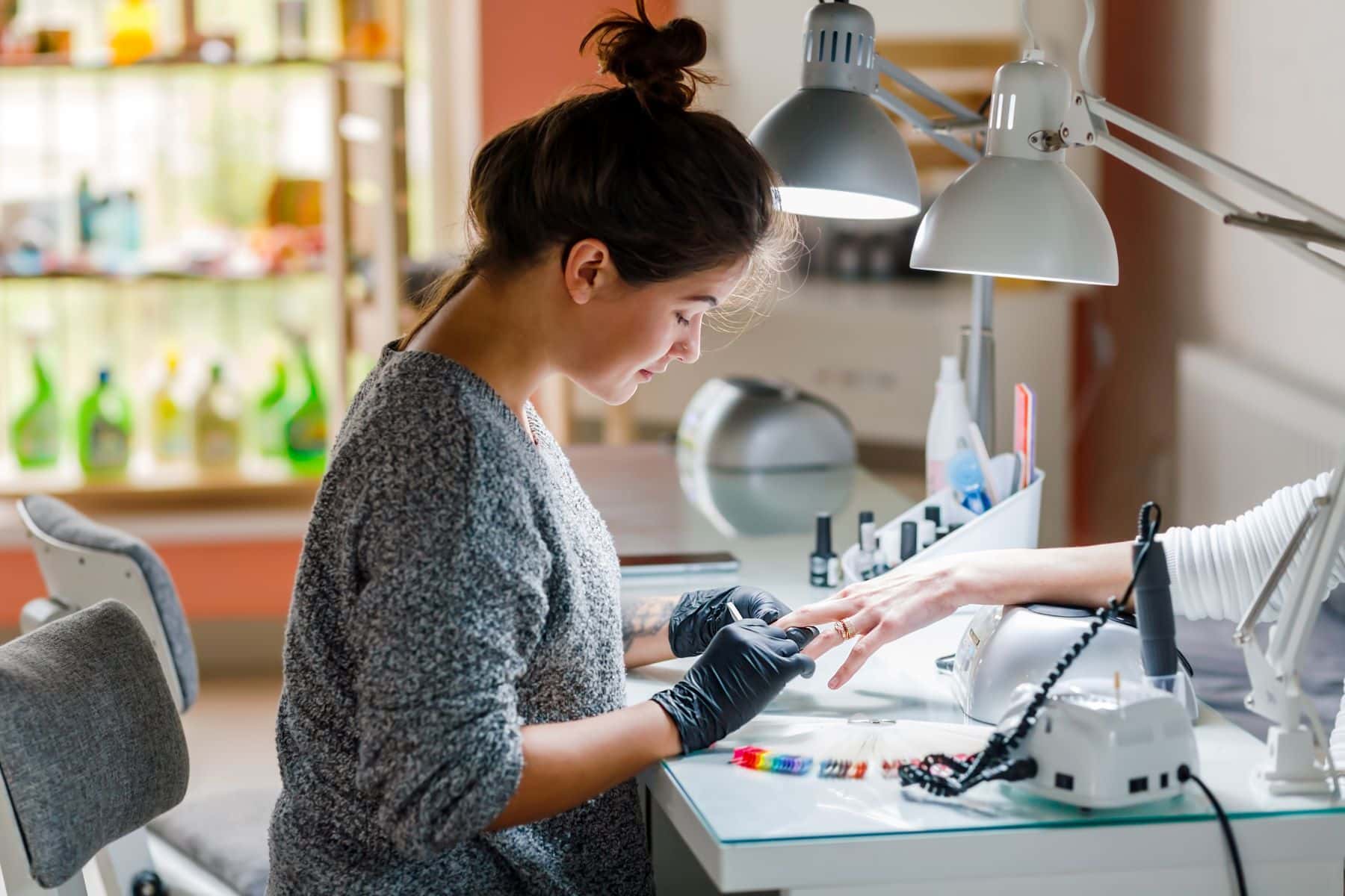 Cosmetologist giving manicure in nail salon