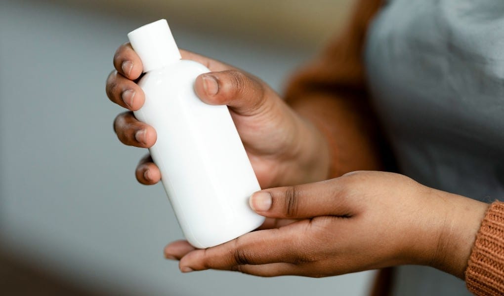 women holding hair product bottle