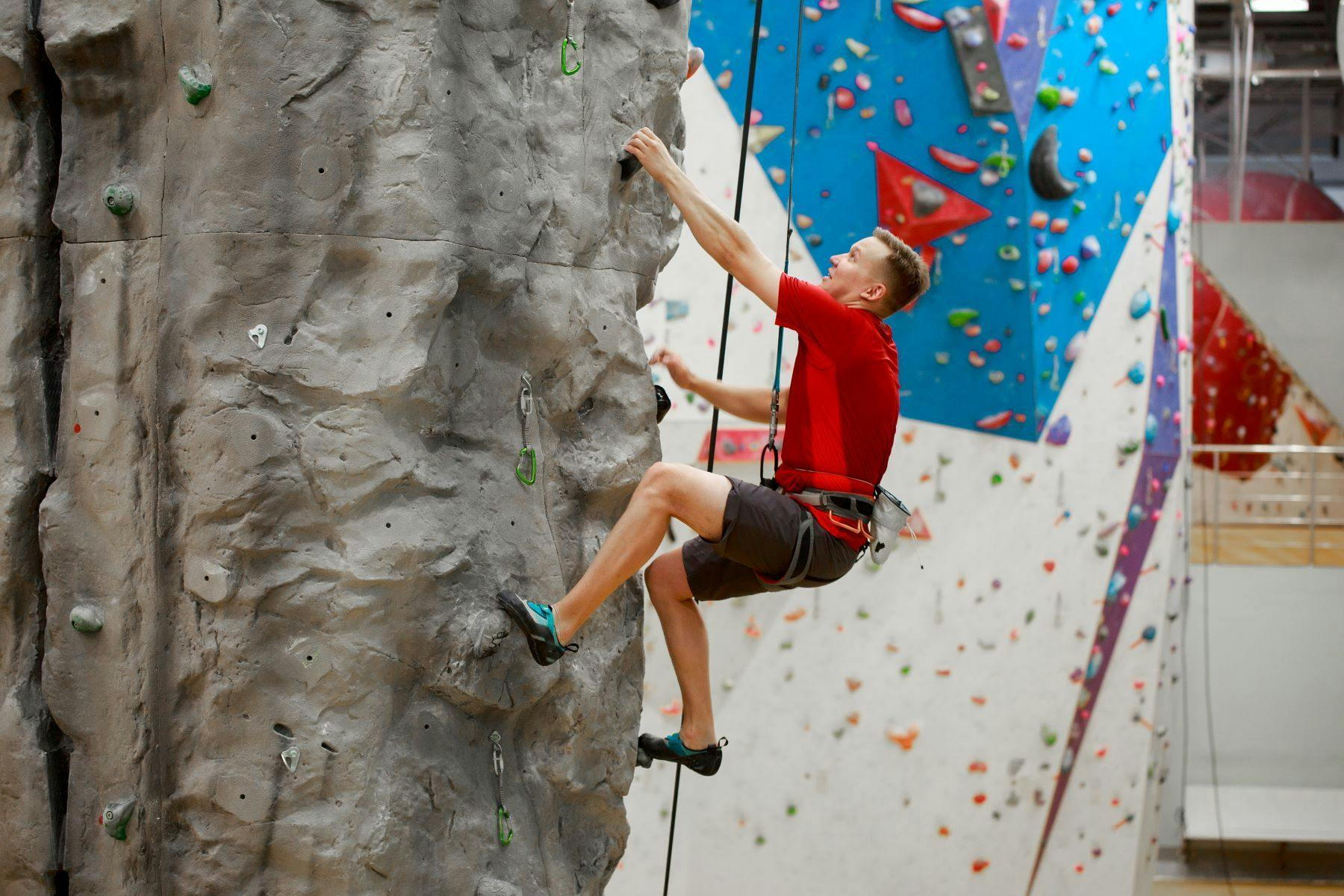 Young man rock climbing on indoor wall